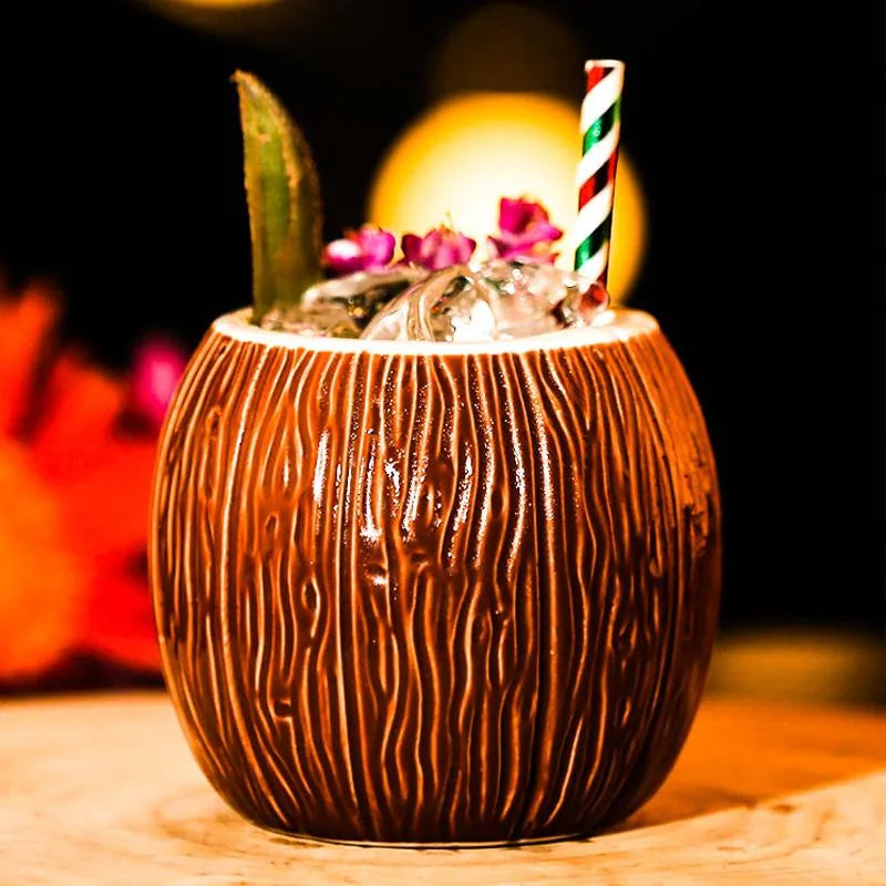 Verre à cocktail noix de coco rempli de glace pilée, décoré d'une fleur et d'une paille rayée, en ambiance de bar tiki