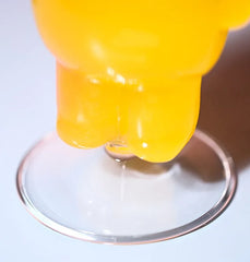 Gros plan sur le pied du verre à cocktail ours rempli de liquide jaune