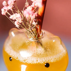 Gros plan sur la tête du verre ours avec cocktail mousseux et fleurs séchées