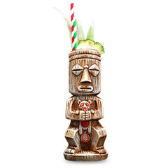 Verre à cocktail Tiki en forme de statue sculptée, posé sur fond blanc avec paille rayée et garniture d'ananas.