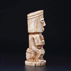 Vue de profil du verre à cocktail tiki en relief sculpté, sur fond noir, mettant en valeur les détails du visage et de la statuette.