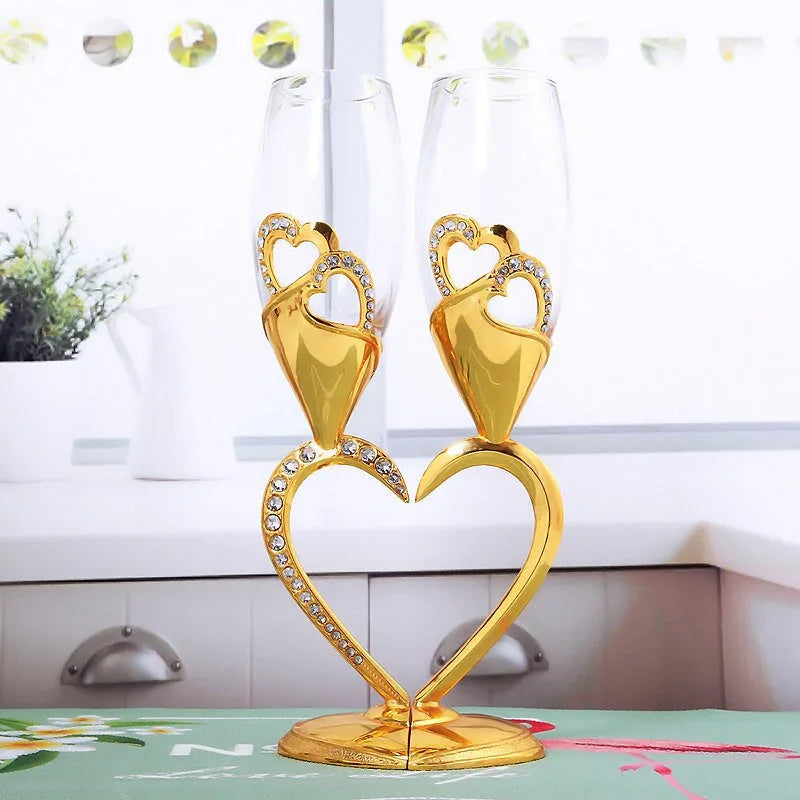 Les verres à cocktail cœur doré posés sur un plan de travail de cuisine lumineux, près d'une plante verte