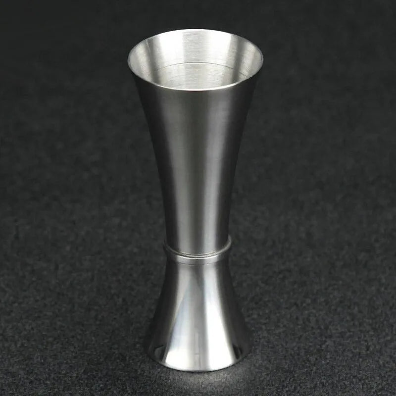 Verre doseur à cocktail en acier inoxydable, vue de profil complète sur fond noir.