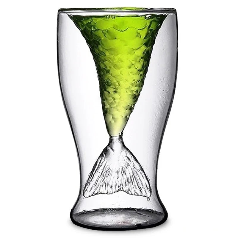 Verre à cocktail en forme de queue de sirène sur fond blanc, rempli d'une boisson verte pétillante