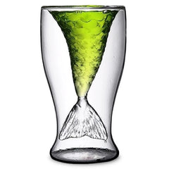 Verre à cocktail en forme de queue de sirène sur fond blanc, rempli d'une boisson verte pétillante