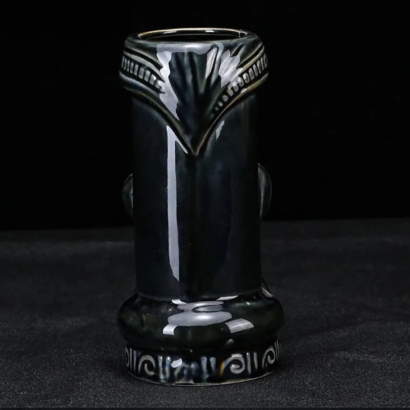 Vue arrière du verre tiki Dieu Noir vide, montrant le motif floral gravé au dos et la base sculptée sur fond noir
