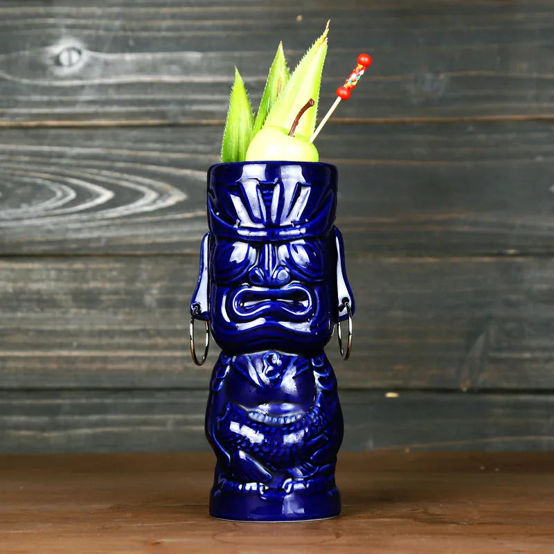 Verre à cocktail tiki Tahiti coloris bleu océan vu de face sur fond bois sombre, garni d'une pomme verte