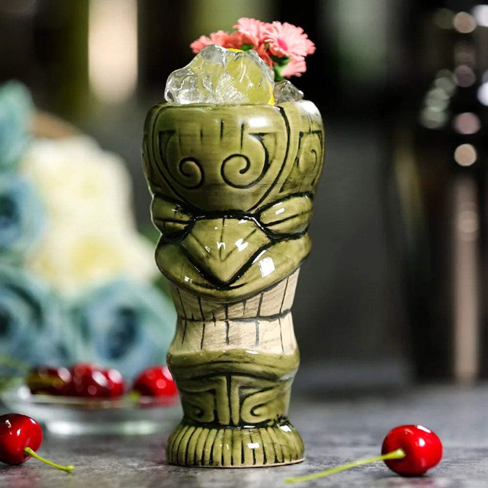 Détail du verre tiki vert garni de fleurs roses et de glaçons, avec des cerises fraîches disposées au premier plan.