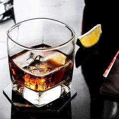 Verre à whisky fond épais garni de romarin et d'un quartier de citron vert, cocktail ambré vu de dessus