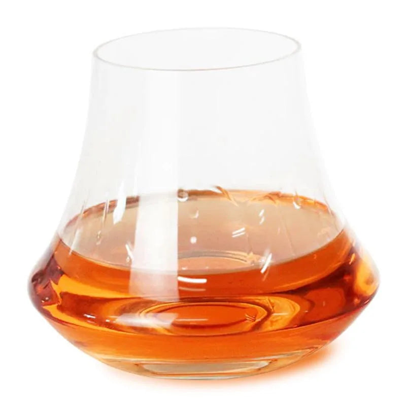 Verre à whisky tulipe moderne rempli de whisky ambré, photographié sur fond blanc.