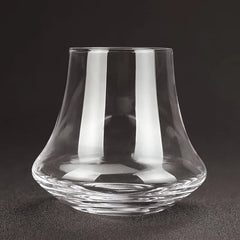 Verre à whisky tulipe moderne vide, photographié sur fond noir en studio.