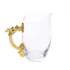 Carafe en verre avec poignée dragon doré, présentée seule sur fond blanc.