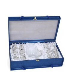 Coffret cadeau bleu ouvert révélant l'ensemble argenté à finition brillante niché dans un écrin en satin blanc.