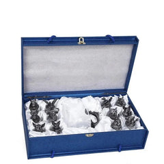 Coffret cadeau bleu ouvert révélant l'ensemble noir niché dans un écrin en satin blanc.