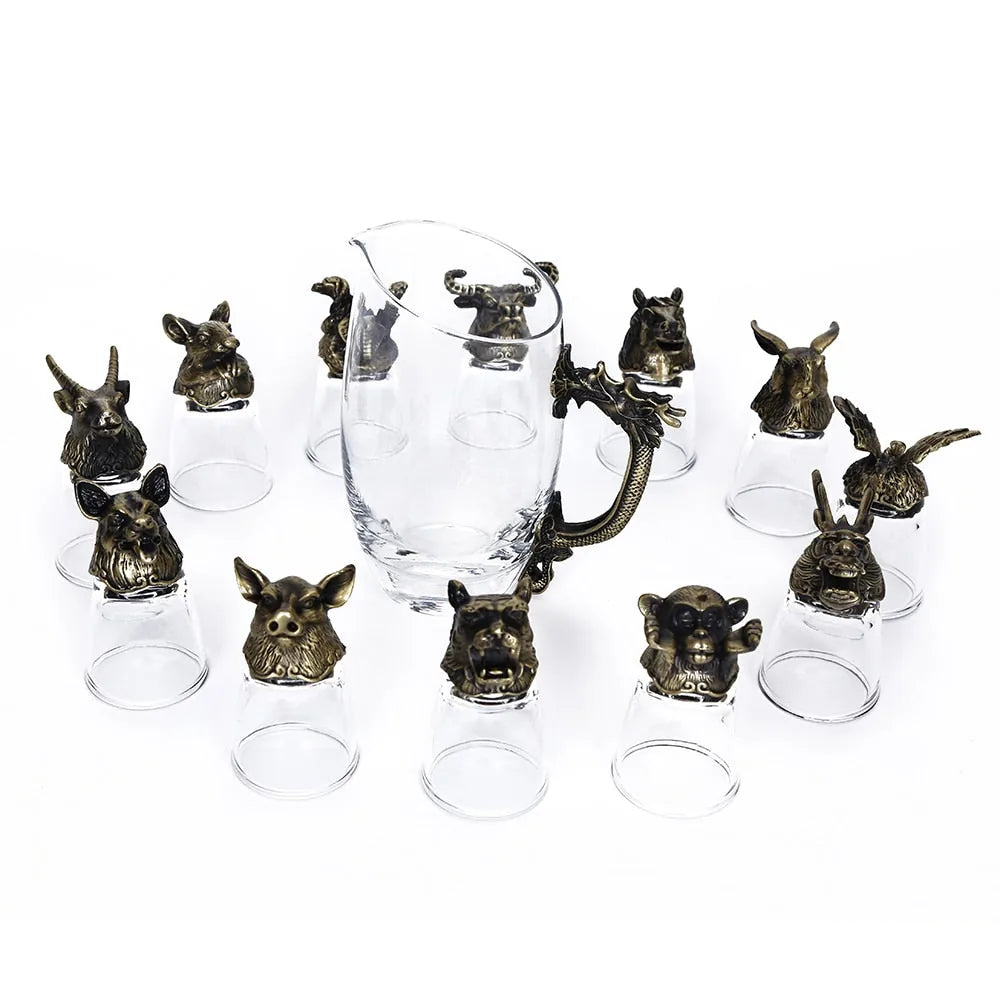 Ensemble complet de 12 verres à shot en finition bronze antique et de leur carafe, présentés en disposition libre sur fond blanc.