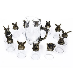 Ensemble complet de 12 verres à shot en finition bronze antique et de leur carafe, présentés en disposition libre sur fond blanc.