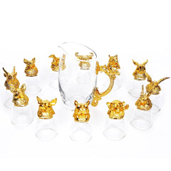 Ensemble complet des 12 verres à shot dorés et de la carafe à poignée dragon, présentés en disposition libre sur fond blanc.