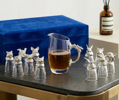 Carafe argentée remplie de whisky ambré posée sur une table en pierre, avec le coffret bleu en velours en arrière-plan.