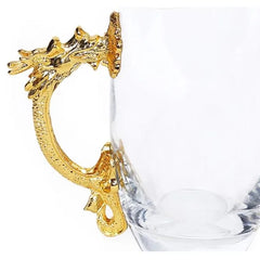 Gros plan sur la poignée en forme de dragon doré de la carafe à cocktail.