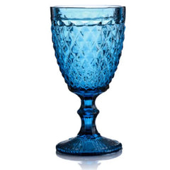 Verre à pied bleu aquatique à motifs facettés, vu de face sur fond blanc
