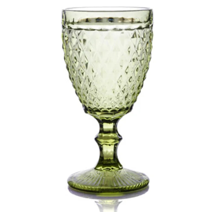 Verre à pied vert printemps à motifs facettés, vu de face sur fond blanc