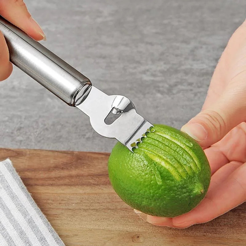 Zesteur à agrumes utilisé à la main pour prélever le zeste d'un citron vert.